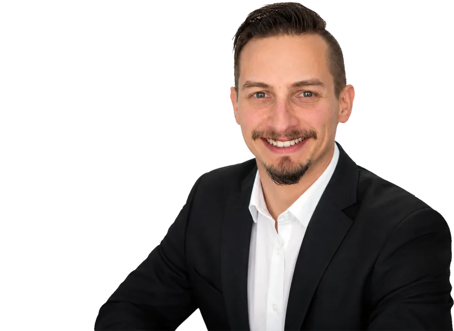 Professional headshot of Patrick Domingues, CEO and Founder of Zevonix, smiling in a black suit and white dress shirt.
