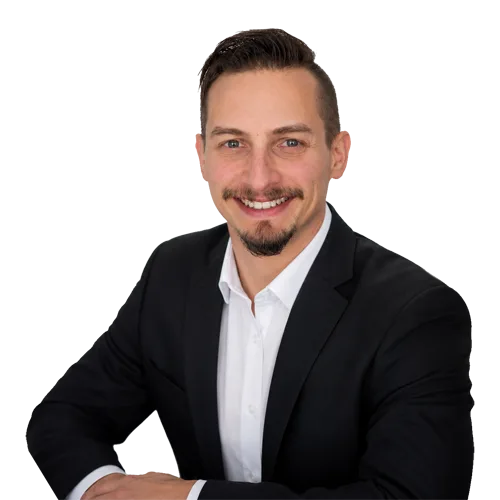 About Us - Patrick Domingues Web Headshot 2026 Small - Zevonix Professional headshot of Patrick Domingues, CEO and Founder of Zevonix, smiling in a black suit and white dress shirt.